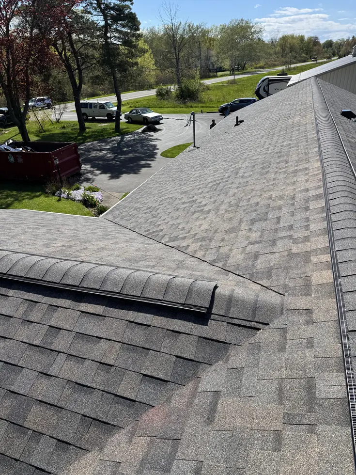 Finished ridge cap on a gray architectural shingle roof in Western New York