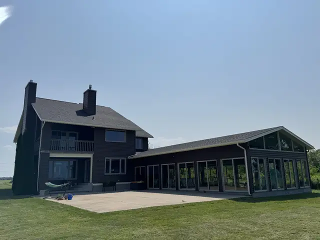 Seamless gutters and downspouts running along the eave of a completed roof in Western New York