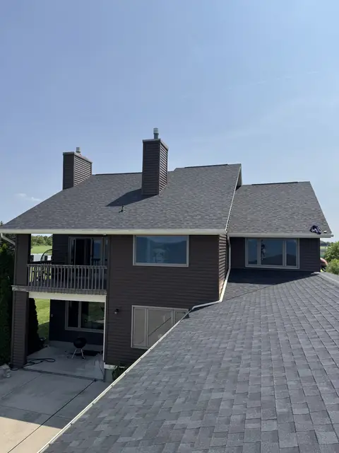Finished roof, two chimneys and fresh flashing seen from the ridge of a WNY home