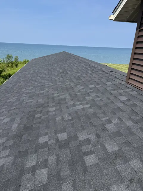 Newly installed architectural shingles and ridge cap running toward the lake on a WNY lakefront home