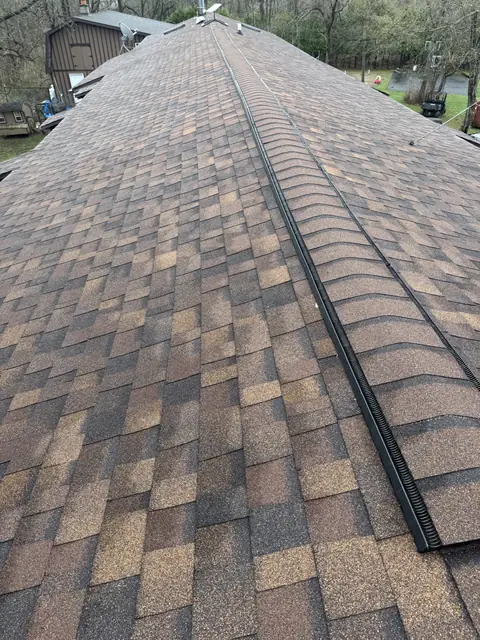Continuous ridge vent running along newly installed architectural shingles