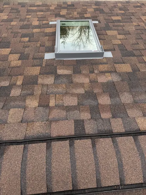 New architectural shingles installed around a skylight on a Western New York home