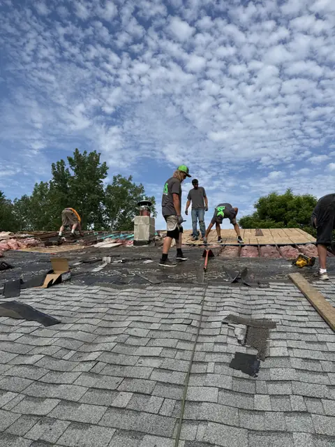 TNE crew stripping an old roof around a masonry chimney in Western New York