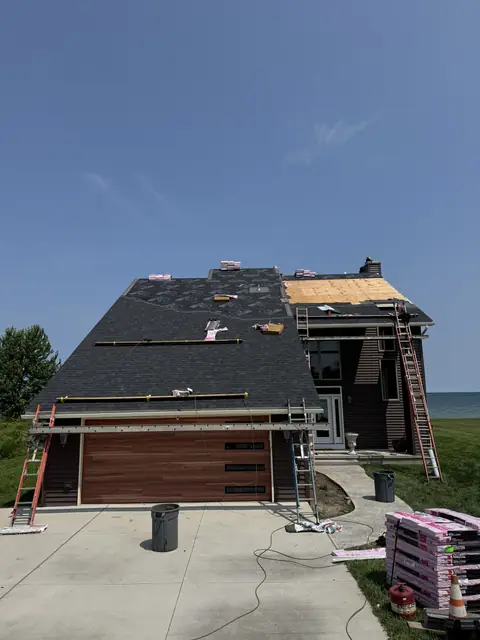 Synthetic underlayment and replacement plywood decking installed over the garage elevation before shingling